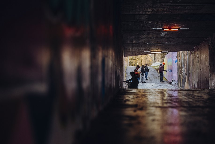 Blick durch eine Unterführung, Jugendliche beim Sprayen