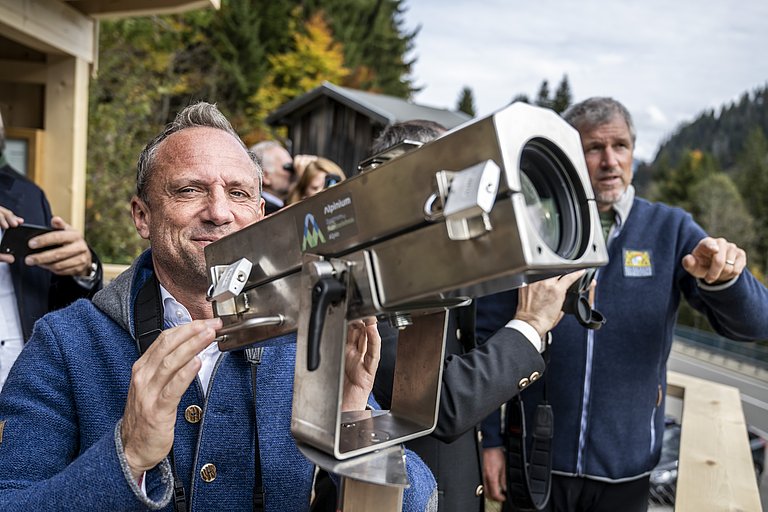 Staatsminister Glaubert beobachtet durch ein Fernrohr Gemse