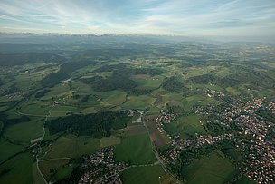 Luftaufnahme von Isny mit Hügeln und Alpenkette