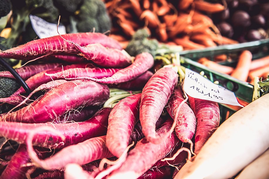 Roter Rettich und Karotten an einem Wochenmarkt-Stand
