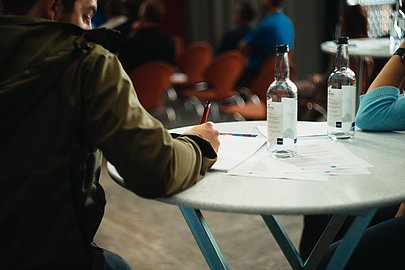 Ein Teilnehmer einer Tagung macht sich Notizen.