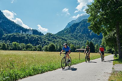 Radfahrer im Allgäu vor dem Tegelberg und dem Schloss Neuschwanstein